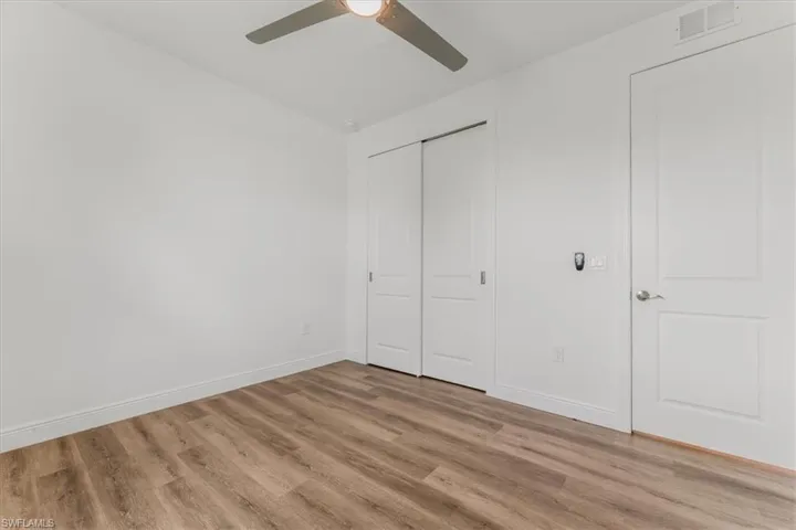 Unfurnished bedroom with light wood-type flooring, a closet, and ceiling fan