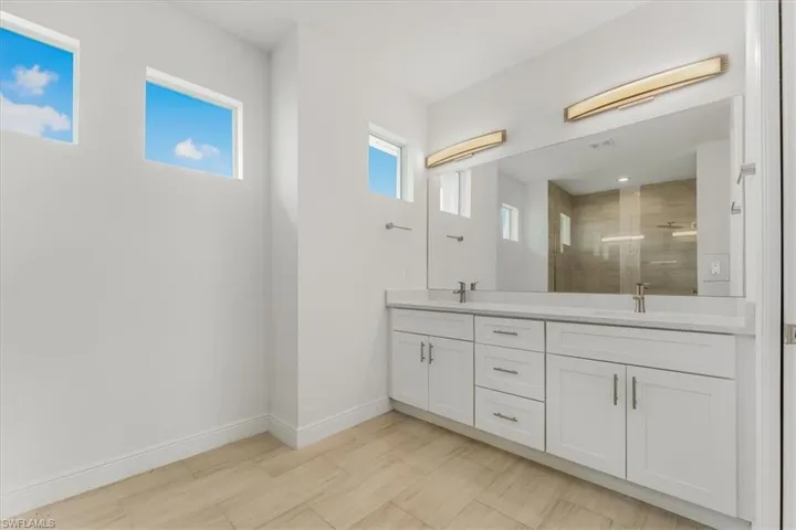 Bathroom featuring double vanity and a shower stall