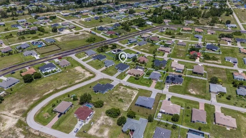 Aerial view of property and surrounding area with nearby suburban area