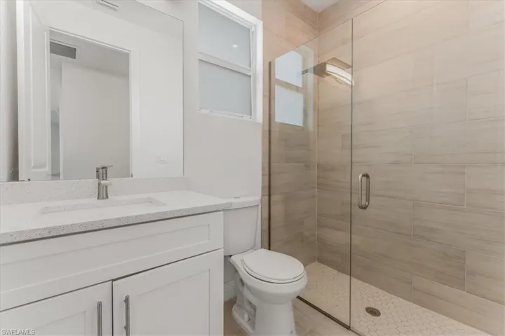Full bath featuring a stall shower and vanity