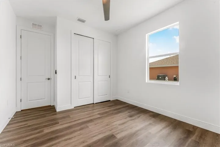 Unfurnished bedroom featuring wood finished floors, a closet, and a ceiling fan