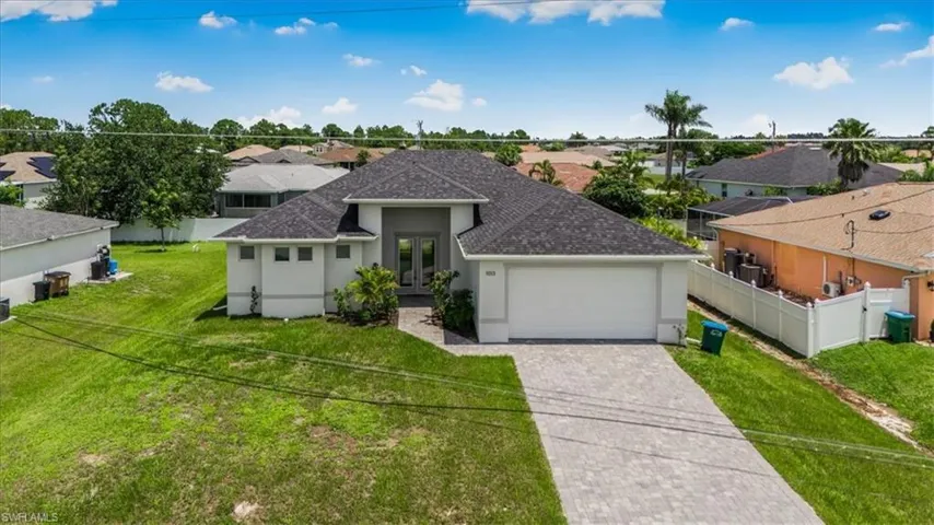 View of front of house with french doors, a shingled roof, an attached garage, stucco siding, and decorative driveway
