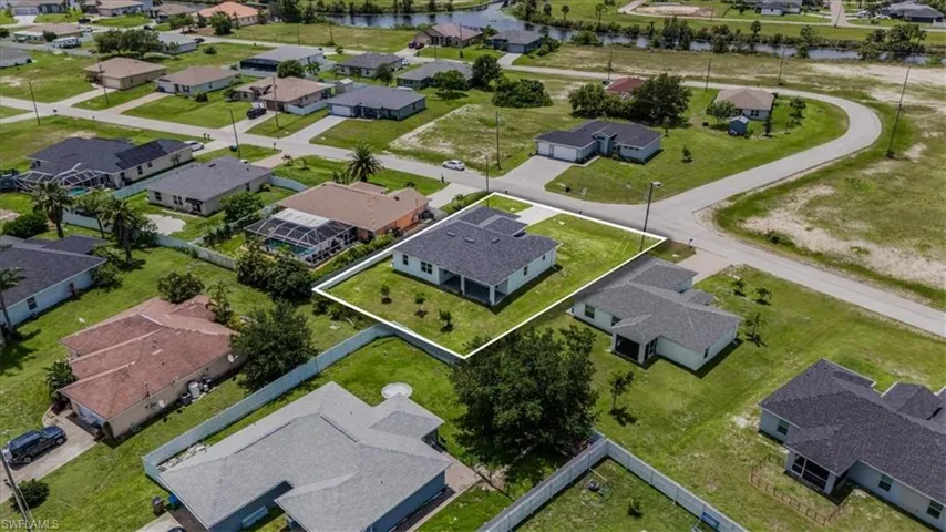 Aerial view of residential area featuring a nearby body of water