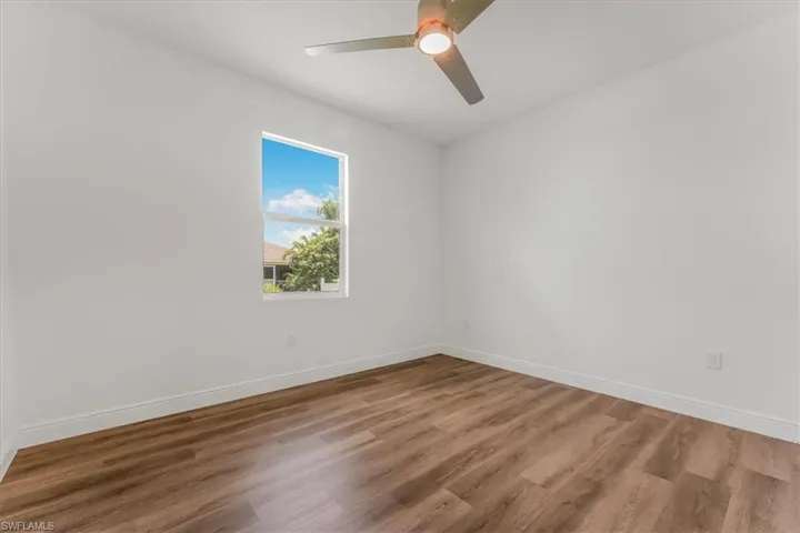 Unfurnished room with wood finished floors and a ceiling fan