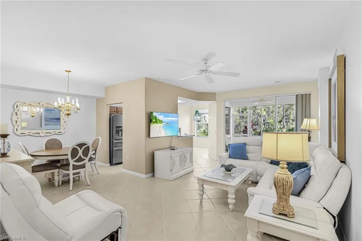 Open-concept living area with neutral tile flooring