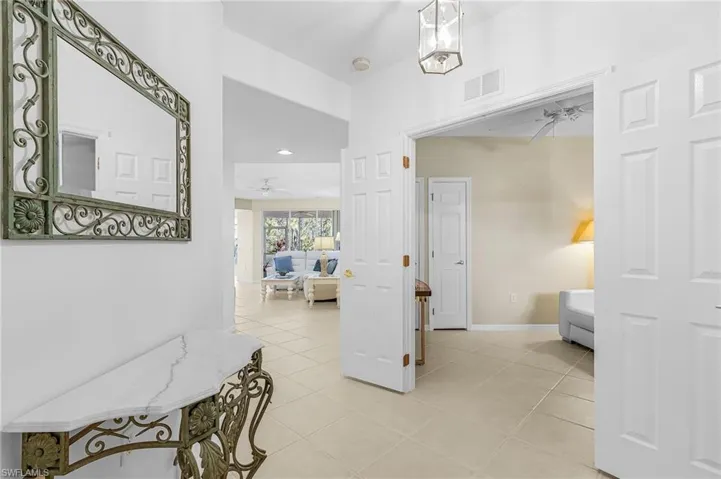 Foyer featuring high ceilings, neutral wall tones, and square tile flooring