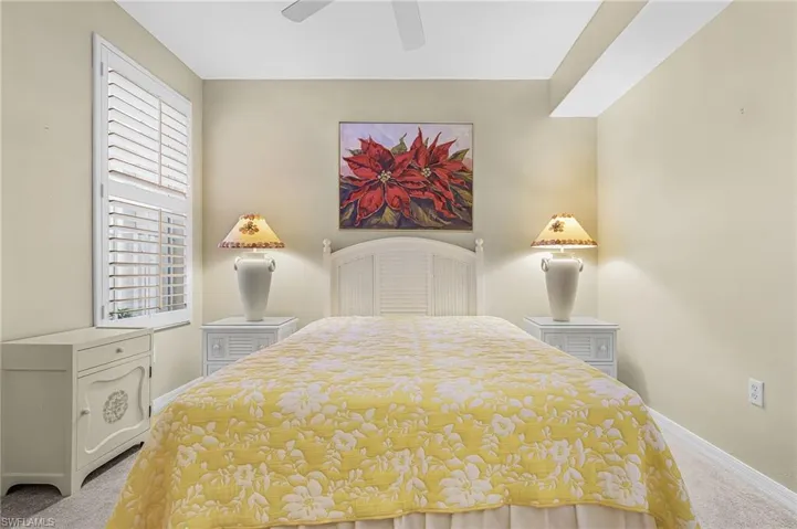 Bedroom featuring a white slatted headboard and matching white nightstands