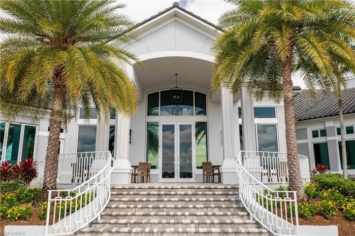 Grand entrance featuring a double-door entry, a covered portico, substantial columns, and a tile roof