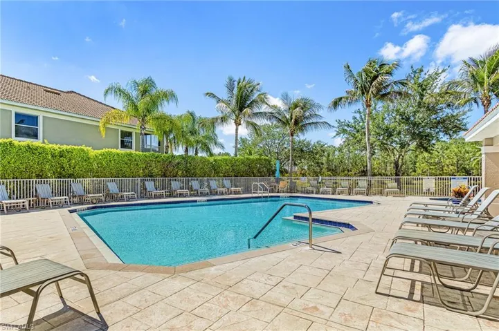 Community swimming pool featuring a tiled perimeter and integrated spa