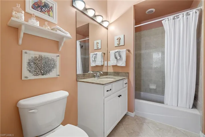 Full bathroom featuring toilet, vanity, tile patterned flooring, and shower / tub combo with curtain
