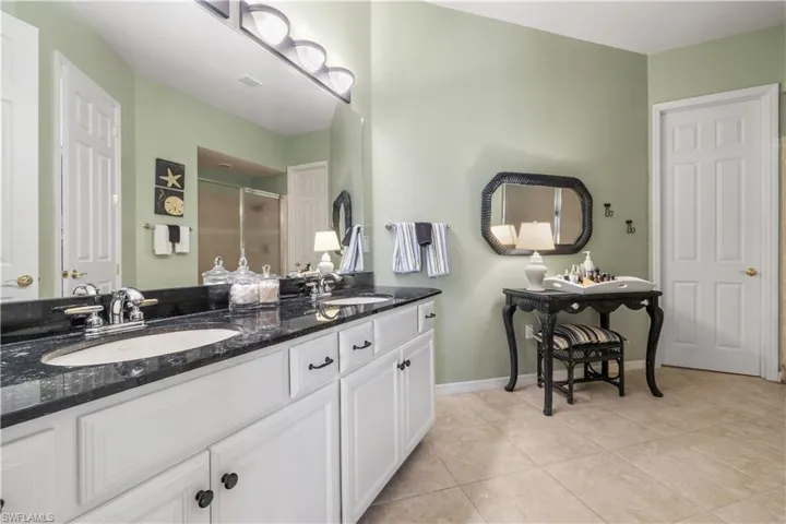 Bathroom featuring vanity, tile patterned floors, and an enclosed shower