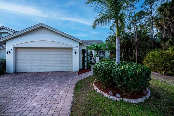 Single story home featuring decorative driveway, an attached garage, and stucco siding