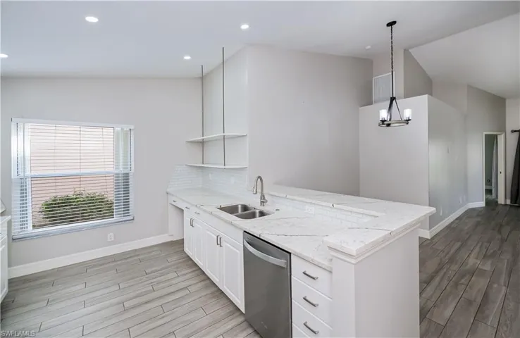 Kitchen featuring decorative light fixtures, open shelves, white cabinets, a sink, and dishwasher