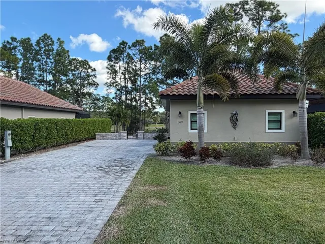 View of side of property with stucco siding, a lawn, and decorative driveway