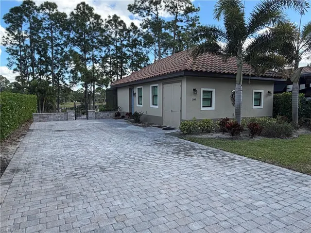 View of home's exterior featuring stucco siding, decorative driveway, and a tile roof
