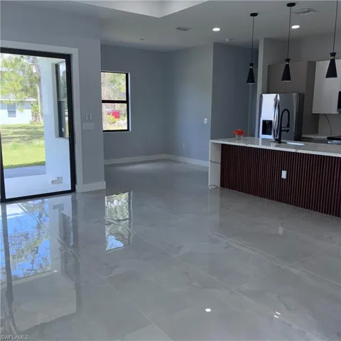 Open-concept living area with polished porcelain tile flooring