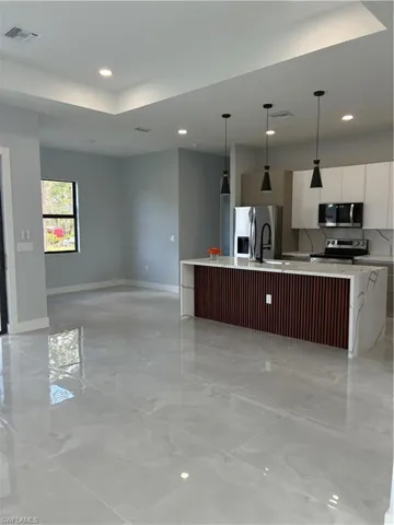 Open-concept living space with polished tile flooring