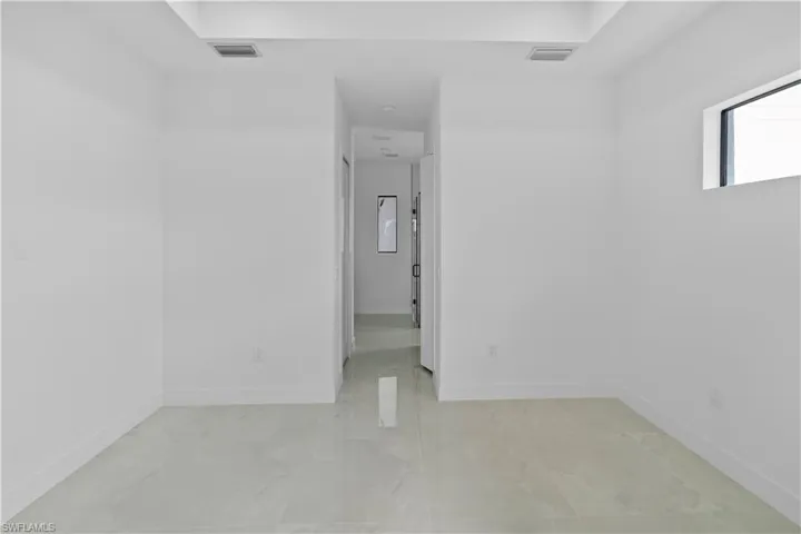 White interior space featuring light-toned tile flooring and white baseboards
