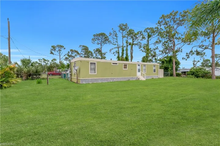 Rear view of house featuring a lawn and entry steps