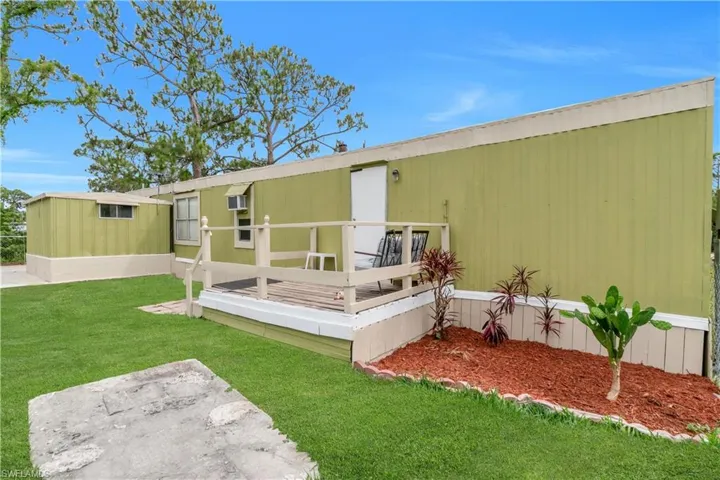 Back of house featuring a yard and a wooden deck