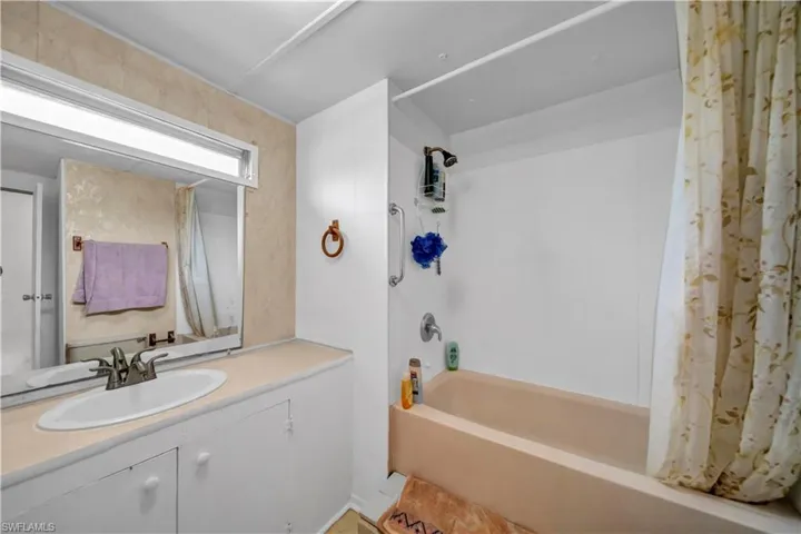 Bathroom with shower / tub combo with curtain and vanity