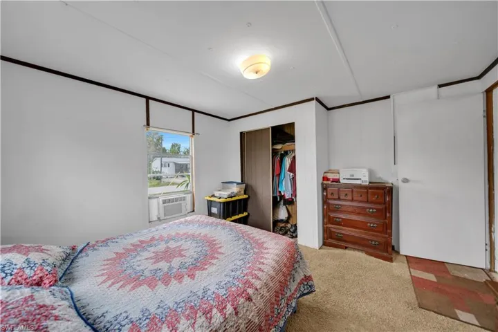 Carpeted bedroom featuring cooling unit and a closet