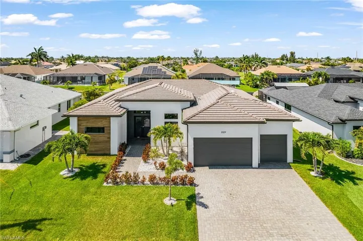 Modern single-story residence featuring a tile roof and clean white exterior
