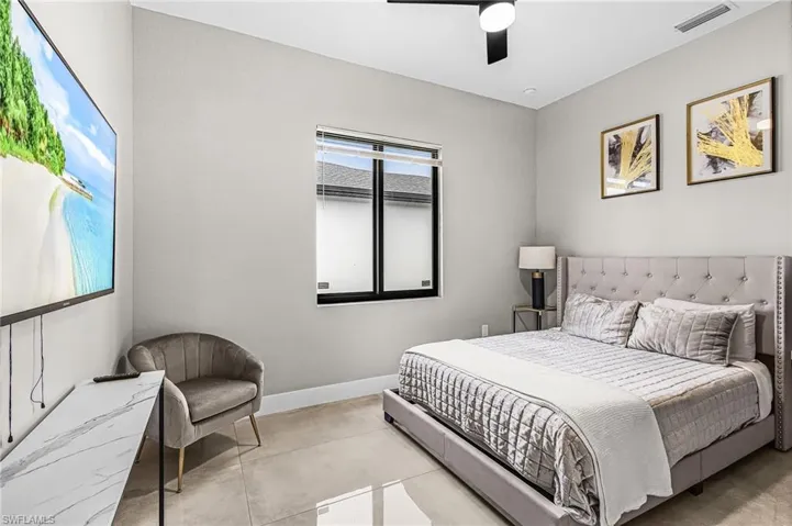 Recessed lighting illuminates the room, featuring a built-in window with horizontal blinds and a black ceiling fan