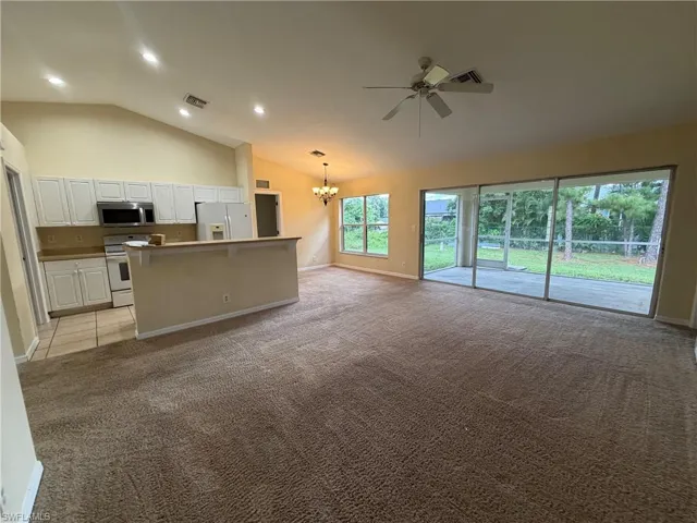 Kitchen with white cabinetry, stainless steel appliances, and a breakfast bar