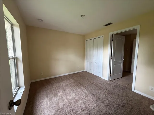 Carpeted flooring, bi-fold closet doors, and painted walls
