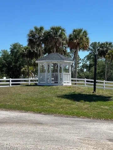Surrounding community with a gazebo, fence, and a lawn
