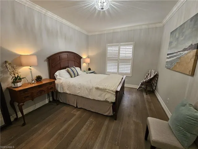 Bedroom featuring ornamental molding and dark wood finished floors