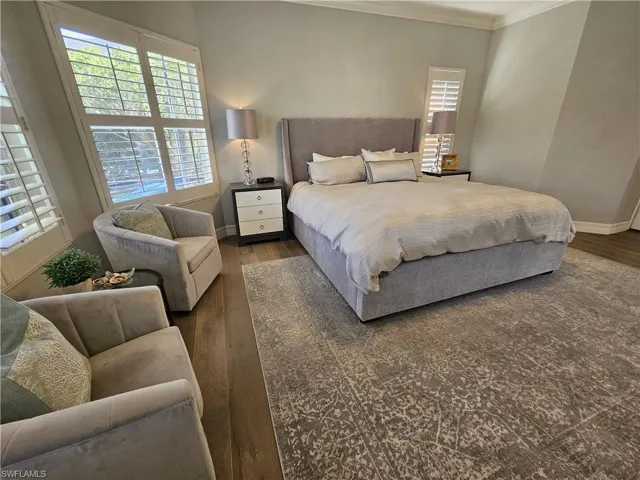 Bedroom featuring ornamental molding and dark wood finished floors