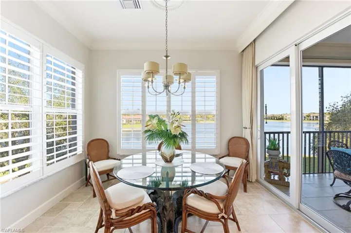 Dining room featuring crown molding, hanging lights, healthy amount of natural light, and a water view
