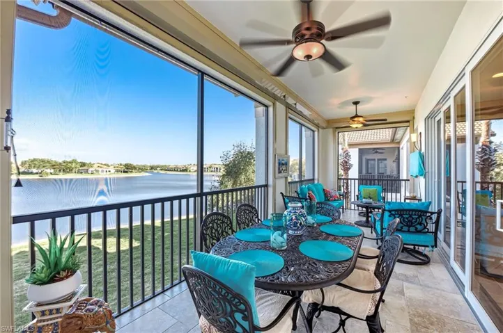 Sunroom featuring ceiling fan, outdoor dining space, a water view, and healthy amount of natural light