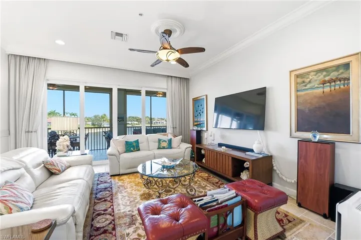 Living area with a ceiling fan and ornamental molding