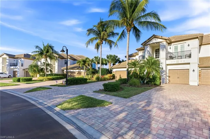 Mediterranean / spanish house with a residential view, stucco siding, decorative driveway, a balcony, and a garage
