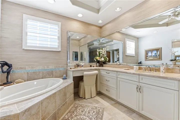 Bathroom with vanity, a garden tub, a ceiling fan, and recessed lighting