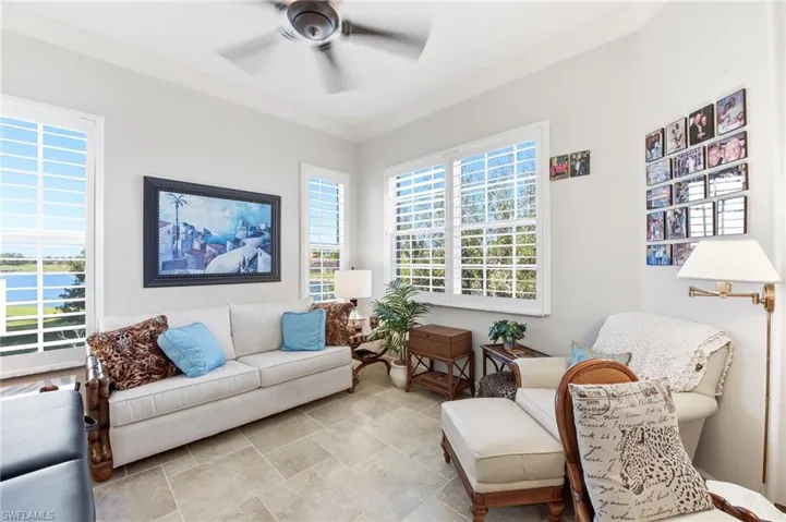 Living area with crown molding, healthy amount of natural light, a ceiling fan, and a water view