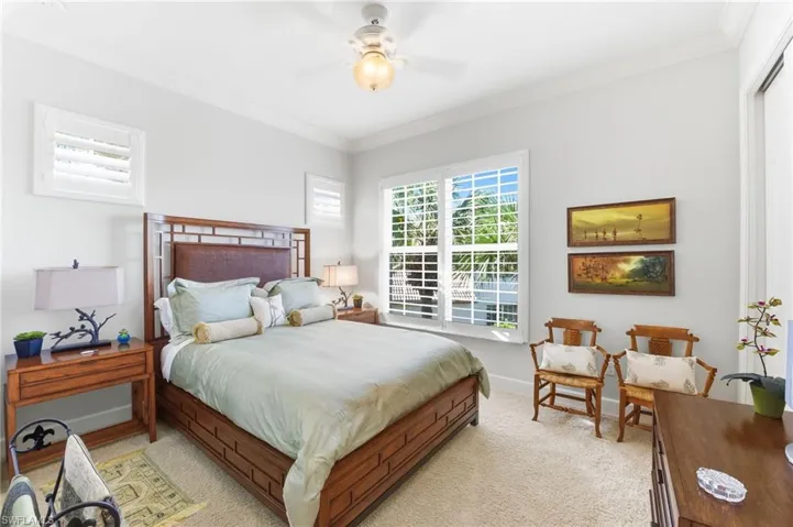Carpeted bedroom with ornamental molding and ceiling fan