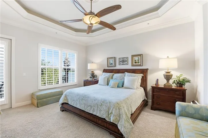 Bedroom featuring access to outside, carpet floors, crown molding, ceiling fan, and a raised ceiling
