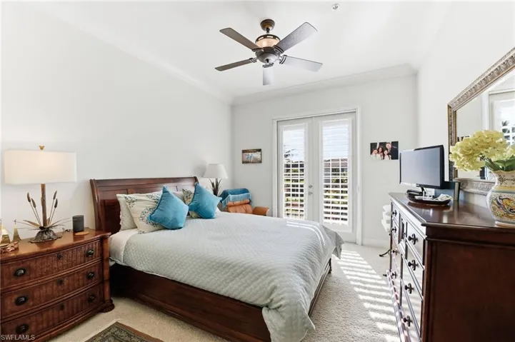 Bedroom with ornamental molding, ceiling fan, french doors, light colored carpet, and access to outside