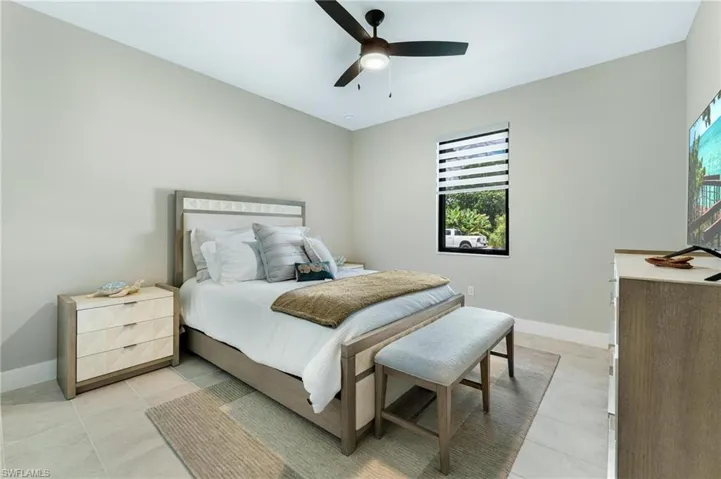 Bedroom featuring light tile patterned floors and ceiling fan