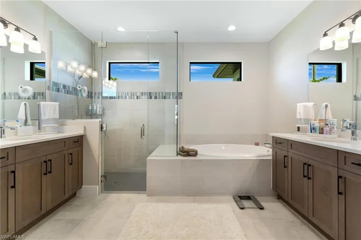 Bathroom with independent shower and bath, vanity, and tile patterned floors