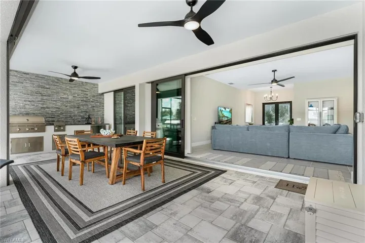 Tiled dining space with ceiling fan with notable chandelier