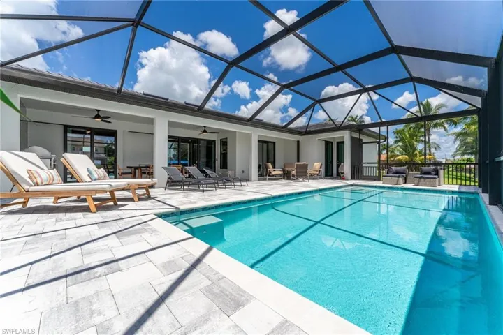 View of pool featuring a lanai, a patio area, and ceiling fan
