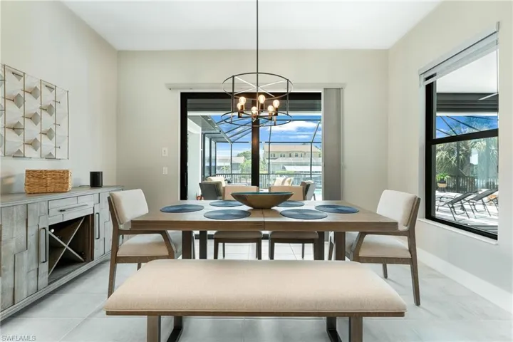 Dining room with a wealth of natural light, light tile patterned floors, and a chandelier