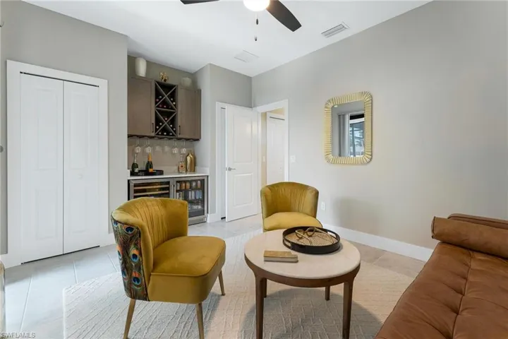 Bedroom beverage cooler, ceiling fan, and light tile patterned floors