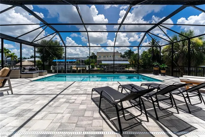 View of swimming pool with a patio and glass enclosure