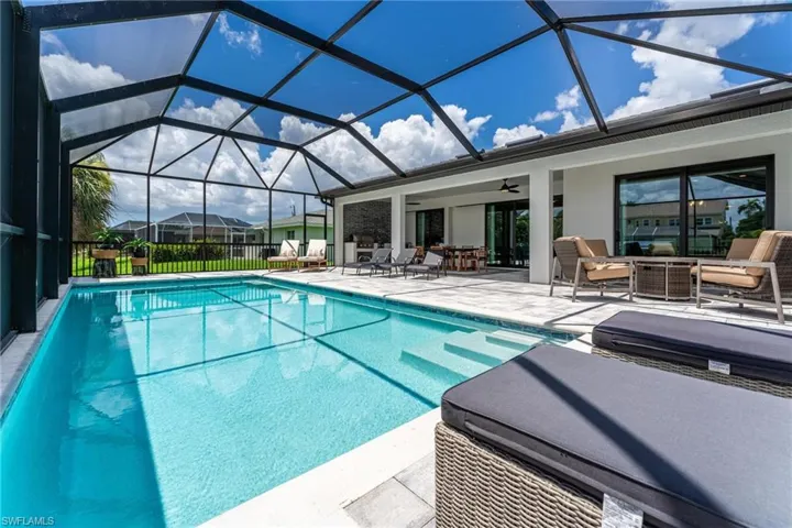 View of swimming pool featuring a lanai, a patio area, outdoor lounge area, and ceiling fan